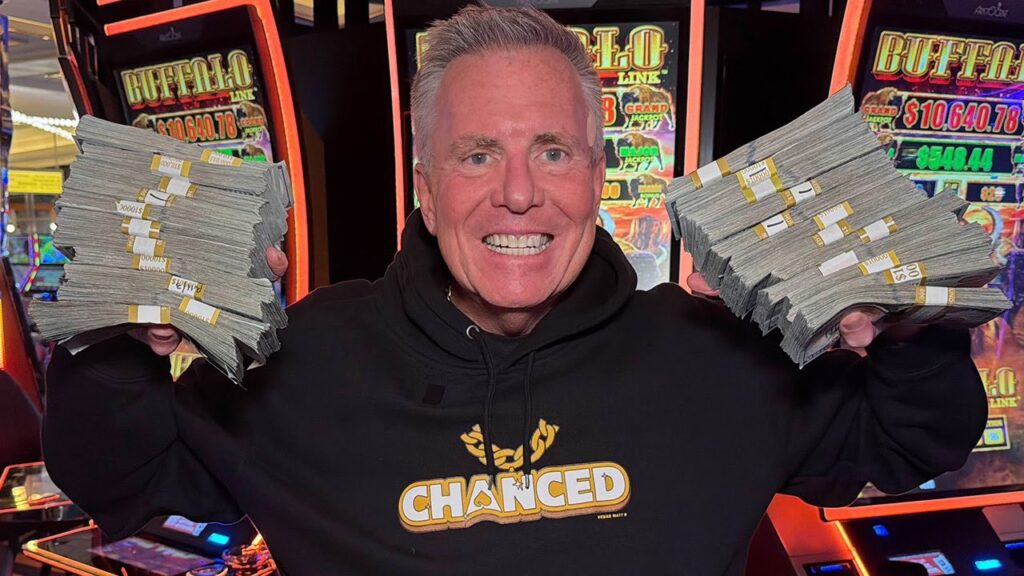 Vegas Matt holds stacks of money while wearing a Chanced hoodie